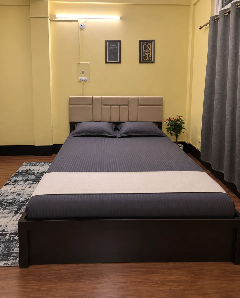 Bedroom 2 with a queen bed, upholstered headboard and framed prints