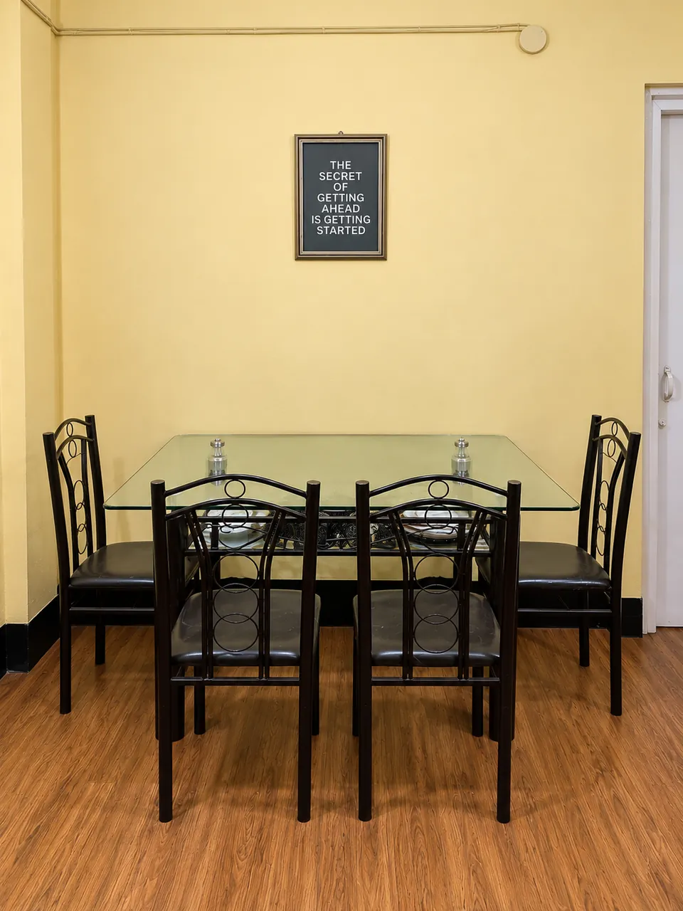 4-seat glass dining table with black chairs