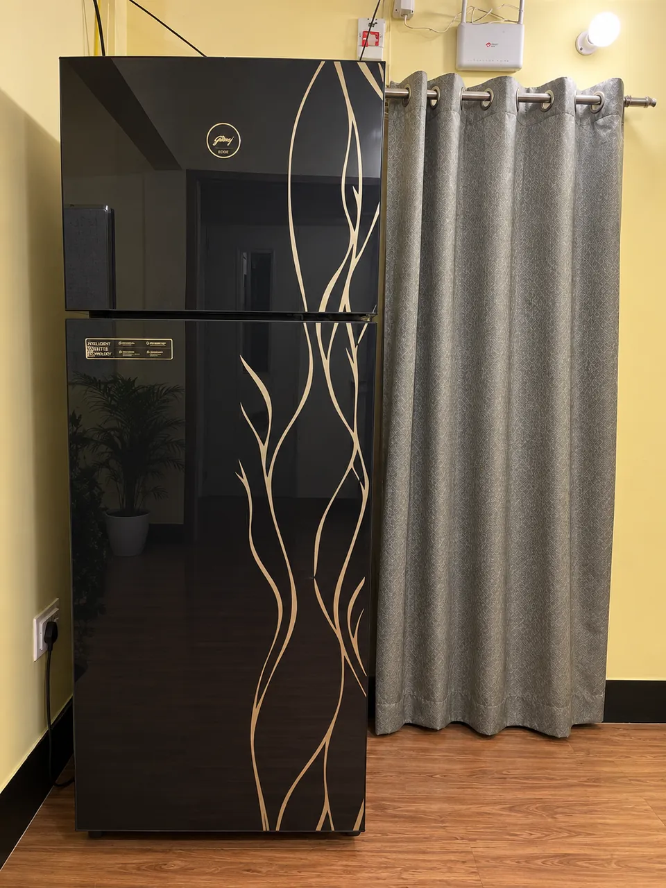 Tall black double-door refrigerator with a gold pattern