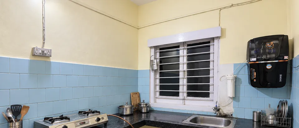 Kitchen counter with a gas stove, sink, water purifier and cookware